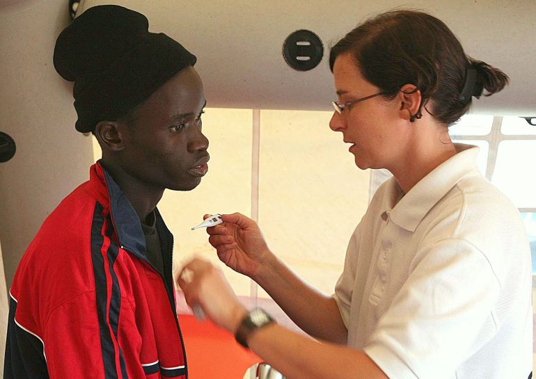 Personal médico atiende a un inmigrante en el puerto de Los Cristianos, Tenerife Personal médico atiende a un inmigrante en el puerto de Los Cristianos, Tenerife