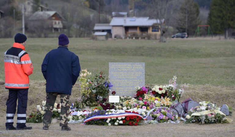 Dos hombres junto al monumento conmemorativo de las víctimas del avión de Germanwings. Dos hombres junto al monumento conmemorativo de las víctimas del avión de Germanwings.