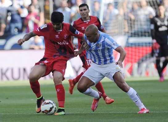 Sevilla's French defender Timothee Kolodziejczak (L) vies with Malaga's Argentinian midfielder Fernando Damian Tissone (R)during the Spanish league football match Malaga CF vs Sevilla FC at La Rosaleda stadium in Malaga on May 23, 2015. AFP PHOTO / CRISTINA QUICLER Sevilla's French defender Timothee Kolodziejczak (L) vies with Malaga's Argentinian midfielder Fernando Damian Tissone (R)during the Spanish league football match Malaga CF vs Sevilla FC at La Rosaleda stadium in Malaga on May 23, 2015. AFP PHOTO / CRISTINA QUICLER