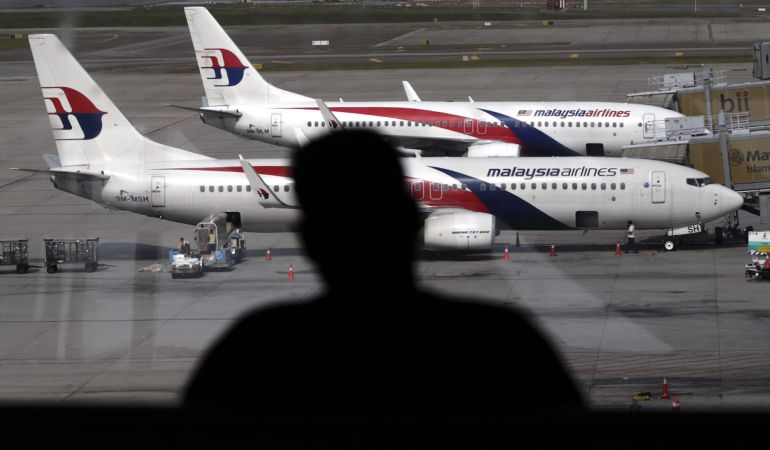 Fotografía de archivo del 19 de julio de 2014 de un pasajero observando aviones de la aerolínea Malaysia Airline en el aeropuerto internacional de Kuala Lumpur (Malasia). Fotografía de archivo del 19 de julio de 2014 de un pasajero observando aviones de la aerolínea Malaysia Airline en el aeropuerto internacional de Kuala Lumpur (Malasia).