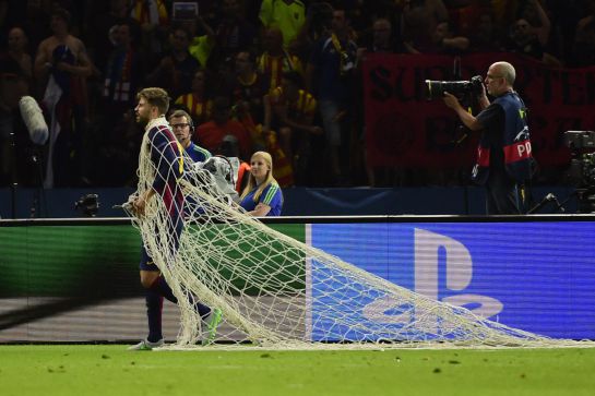 Barcelona's defender Gerard Pique has wrapped himself in the cut goal net after the UEFA Champions League Final football match between Juventus and FC Barcelona at the Olympic Stadium in Berlin on June 6, 2015. FC Barcelona won the match 1-3. AFP PHOTO / OLIVIER MORIN Barcelona's defender Gerard Pique has wrapped himself in the cut goal net after the UEFA Champions League Final football match between Juventus and FC Barcelona at the Olympic Stadium in Berlin on June 6, 2015. FC Barcelona won the match 1-3. AFP PHOTO / OLIVIER MORIN