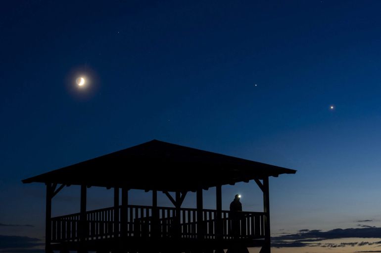 (De izda a dcha, en el cielo) La luna, Júpiter y Venus son observados desde el mirador de Mogyorosi cerca de Salgotarjan en Hungría. (De izda a dcha, en el cielo) La luna, Júpiter y Venus son observados desde el mirador de Mogyorosi cerca de Salgotarjan en Hungría.