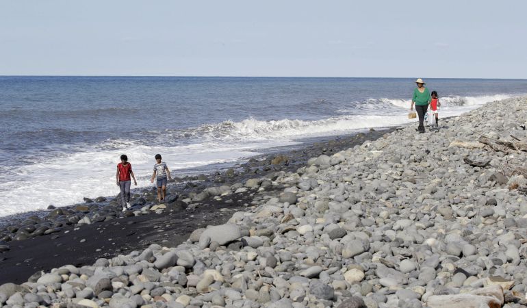 Gente caminando por la playa en la se encontraron escombros de avión situada en la isla francesa de La Reunión. Gente caminando por la playa en la se encontraron escombros de avión situada en la isla francesa de La Reunión.