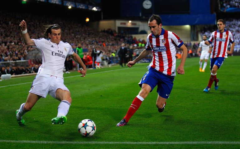Diego Godín pelea el balón ante Gareth Bale. Diego Godín pelea el balón ante Gareth Bale.