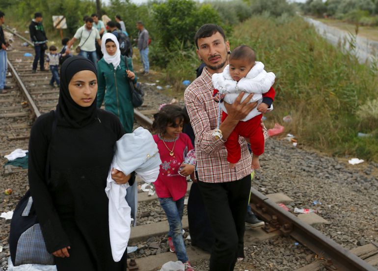 Una familia de refugiados sirios camina por la vía del tren que cruza entre Serbia y Hungría. Una familia de refugiados sirios camina por la vía del tren que cruza entre Serbia y Hungría.