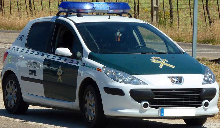 Un coche de la Guardia Civil, de patrulla por una carretera Un coche de la Guardia Civil, de patrulla por una carretera