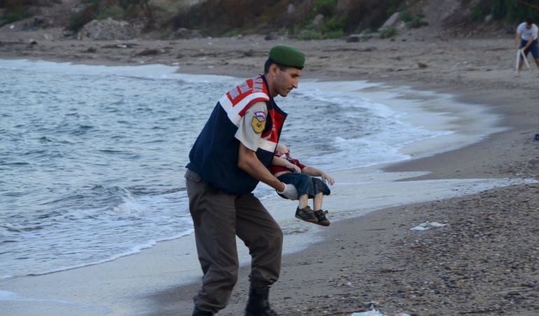 Un agente de la gendarmería turca recoge el cadáver del menor fallecido cauando intentaba llegar a Europa con su familia. Un agente de la gendarmería turca recoge el cadáver del menor fallecido cauando intentaba llegar a Europa con su familia.