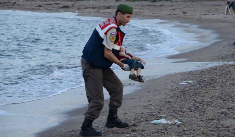 Un agente de la gendarmería turca recoge el cadáver del menor fallecido cauando intentaba llegar a Europa con su familia. Un agente de la gendarmería turca recoge el cadáver del menor fallecido cauando intentaba llegar a Europa con su familia.