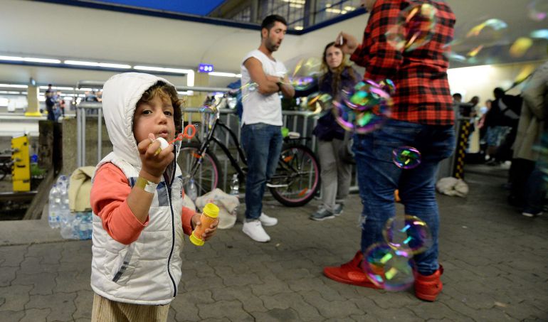 Un niño sirio juega con un pompero en la estación de trenes de Viena. Un niño sirio juega con un pompero en la estación de trenes de Viena.