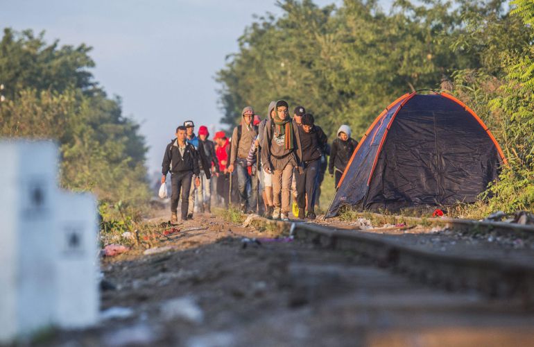 Migrantes procedentes de Serbia caminan por la vía del tren junto a la población fronteriza de Roszke. Migrantes procedentes de Serbia caminan por la vía del tren junto a la población fronteriza de Roszke.