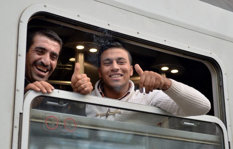 Dos refugiados saludan desde un tren con destino a Freilassing, Alemania, en la estación de Salzburgo Dos refugiados saludan desde un tren con destino a Freilassing, Alemania, en la estación de Salzburgo