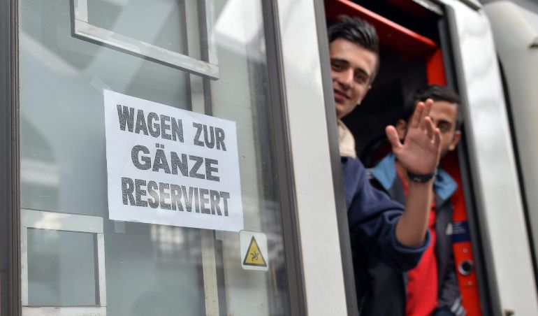 Dos refugiados saludan desde un tren con destino a Freilassing, Alemania, en la estación de Salzburgo. Dos refugiados saludan desde un tren con destino a Freilassing, Alemania, en la estación de Salzburgo.