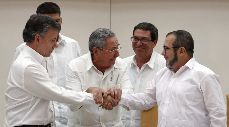 El presidente de Colombia Juan Manuel Santos, el presidente de Cuba Raúl Castro y el máximo líder de las FARC, Rodrigo Londoño, alias "Timochenko", se dan la mano en un acto en La Habana (Cuba). El presidente de Colombia Juan Manuel Santos, el presidente de Cuba Raúl Castro y el máximo líder de las FARC, Rodrigo Londoño, alias "Timochenko", se dan la mano en un acto en La Habana (Cuba).