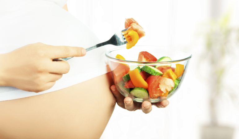Mujer embarazada comiendo. Mujer embarazada comiendo.