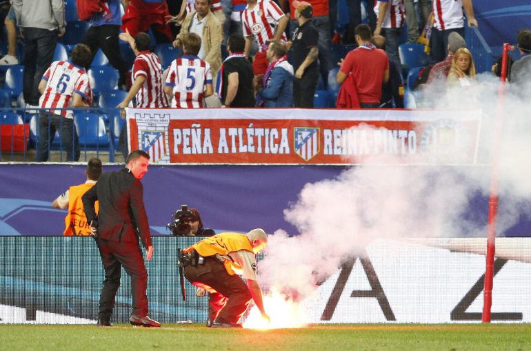 Operarios retiran una bengala del terreno de juego Operarios retiran una bengala del terreno de juego