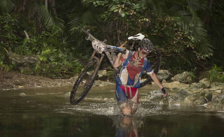 Algunos participantes han tenido que echarse la bici al hombro para cruzar un río con su bicicleta. Algunos participantes han tenido que echarse la bici al hombro para cruzar un río con su bicicleta.