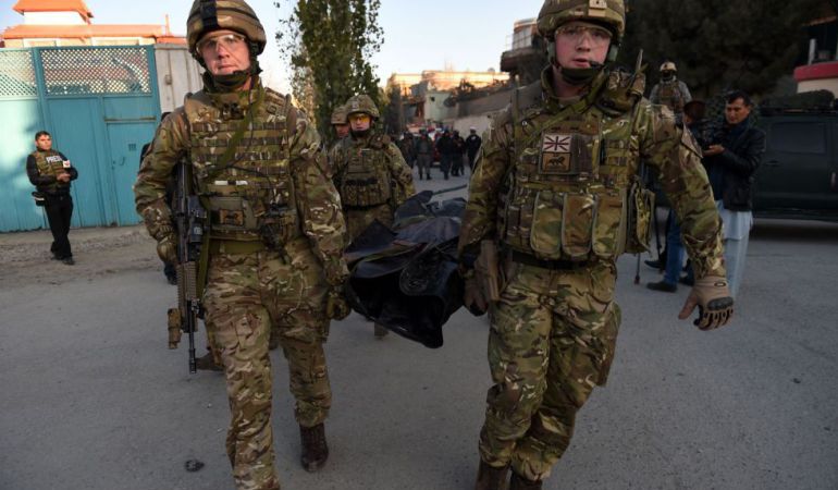 Soldados internacionales evacúan un cuerpo tras el atentando de Kabul. Soldados internacionales evacúan un cuerpo tras el atentando de Kabul.