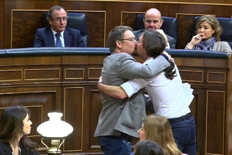 El líder de Podemos, Pablo Iglesias (d), y el de En Comú Podem, Xavier Doménech, se besa en los labios al término de la intervención del diputado catalán. El líder de Podemos, Pablo Iglesias (d), y el de En Comú Podem, Xavier Doménech, se besa en los labios al término de la intervención del diputado catalán.