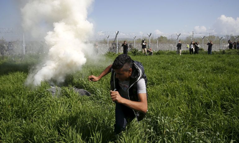 Una bomba lacrimógena cae cerca de un refugiado en la frontera macedonia. Una bomba lacrimógena cae cerca de un refugiado en la frontera macedonia.