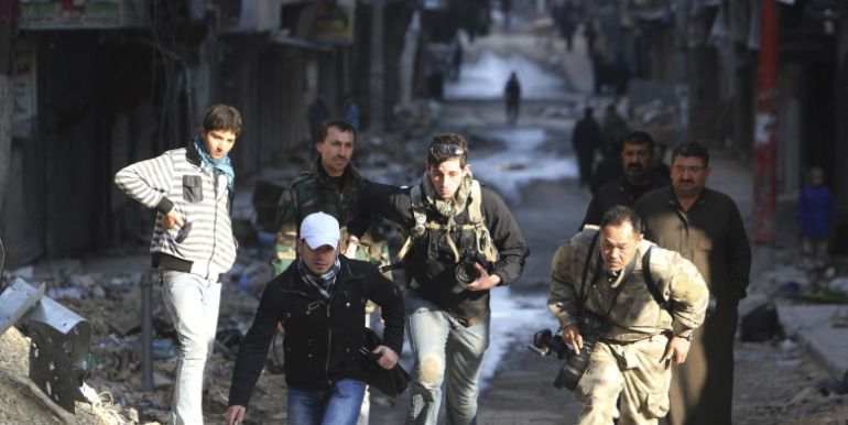 Varios periodistas corren en una calle de Alepo, Siria. Varios periodistas corren en una calle de Alepo, Siria.