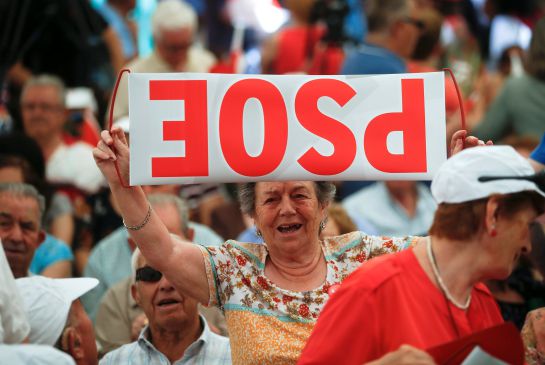 Una votante del PSOE muestra un cartel al revés de la formación. Una votante del PSOE muestra un cartel al revés de la formación.