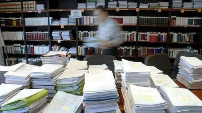 Documentos apilados en una sede administrativa Documentos apilados en una sede administrativa