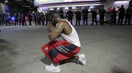 Un joven se arrodilla frente a los policías desplegados durante una manifestación contra la violencia policial hacia los negros en EEUU. Un joven se arrodilla frente a los policías desplegados durante una manifestación contra la violencia policial hacia los negros en EEUU.
