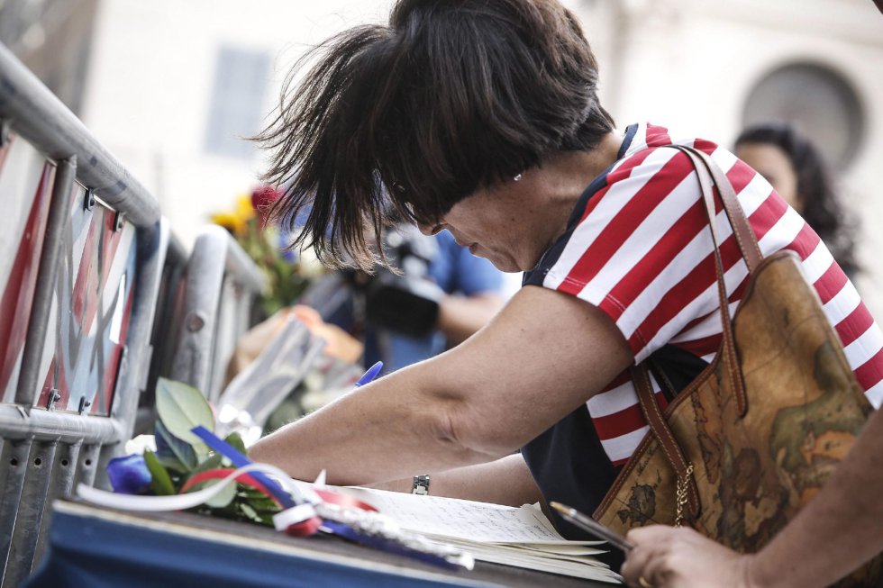 Una mujer firma el libro de condolencias dejado delante de la embajada de Francia en Roma (Italia). Una mujer firma el libro de condolencias dejado delante de la embajada de Francia en Roma (Italia).