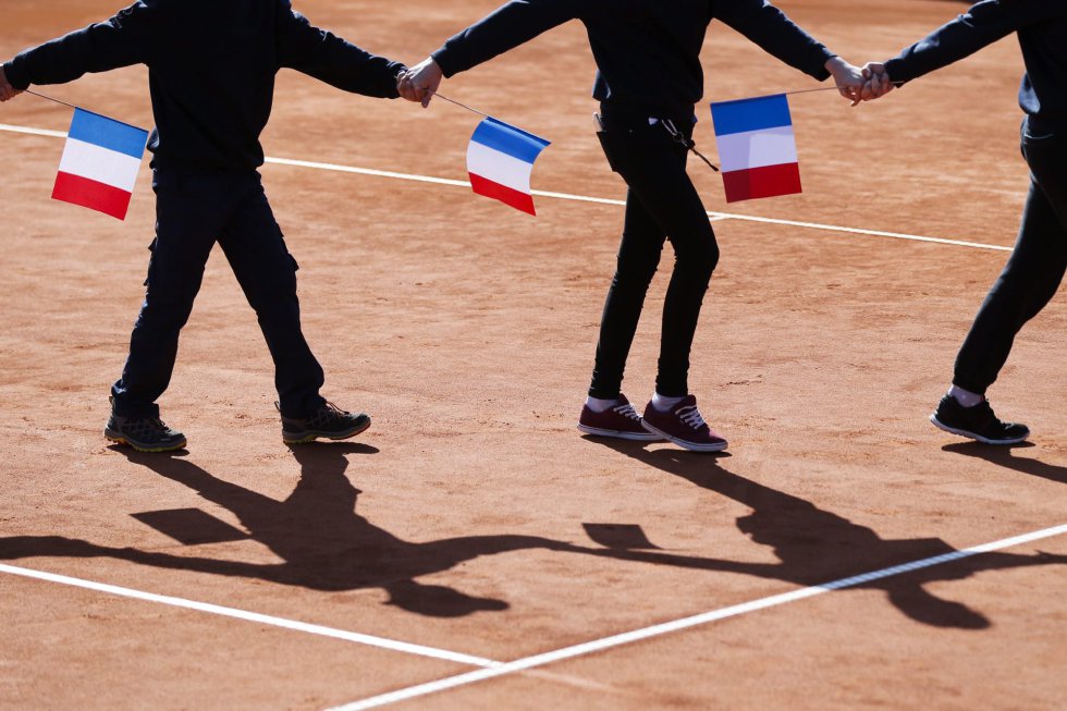 Los recogepelotas forman una cadena humana sosteniendo banderas francesas mientras guardan un minuto de silencio en memoria de las víctimas de la masacre de Niza durante la jornada femenina del torneo de Gstaad. Los recogepelotas forman una cadena humana sosteniendo banderas francesas mientras guardan un minuto de silencio en memoria de las víctimas de la masacre de Niza durante la jornada femenina del torneo de Gstaad.