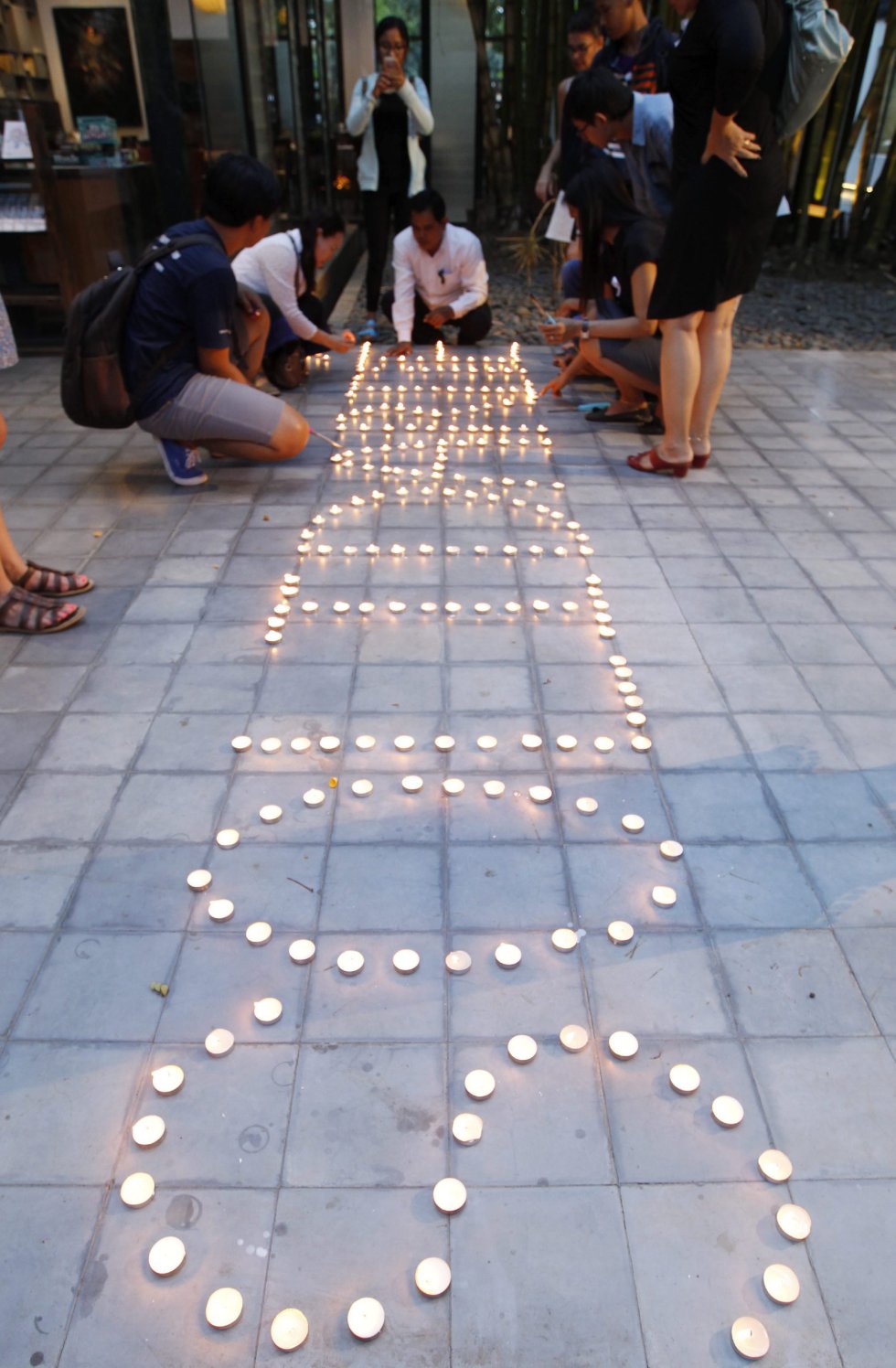 Varios ciudadanos encienden velas durante una ceremonia en el Instituto Francés de Phnom Penh (Camboya). Varios ciudadanos encienden velas durante una ceremonia en el Instituto Francés de Phnom Penh (Camboya).