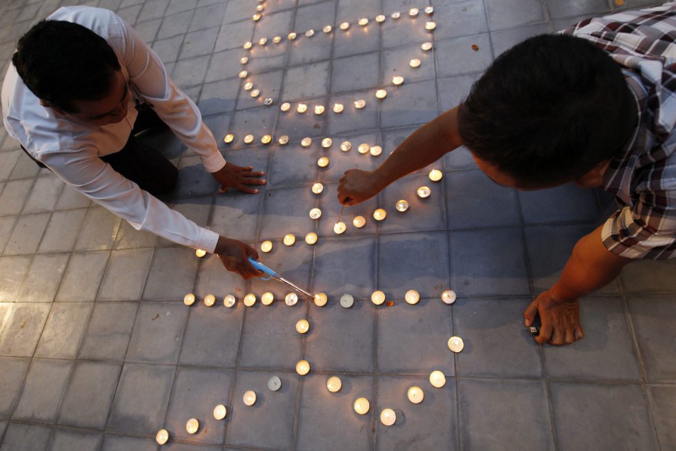 Varios ciudadanos encienden velas durante una ceremonia en el Instituto Francés de Phnom Penh (Camboya). Varios ciudadanos encienden velas durante una ceremonia en el Instituto Francés de Phnom Penh (Camboya).
