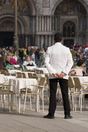 Un camarero, atento a los clientes de la terraza. Un camarero, atento a los clientes de la terraza.