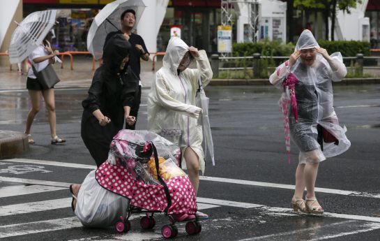 Tres mujeres se protegen de la lluvia y el fuerte viento provocado por el tifón Mindulle en Tokio. Tres mujeres se protegen de la lluvia y el fuerte viento provocado por el tifón Mindulle en Tokio.