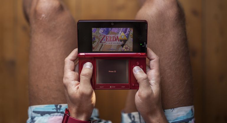 Un hombre jugando a Zelda: A Link Between Worlds Un hombre jugando a Zelda: A Link Between Worlds