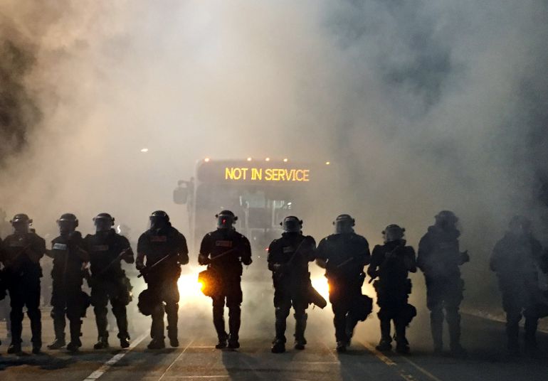 Policias tratando de contener a los manifestantes en Carolina del Norte, que protestan por la muerte a manos de un agente de un hombre de color. Policias tratando de contener a los manifestantes en Carolina del Norte, que protestan por la muerte a manos de un agente de un hombre de color.