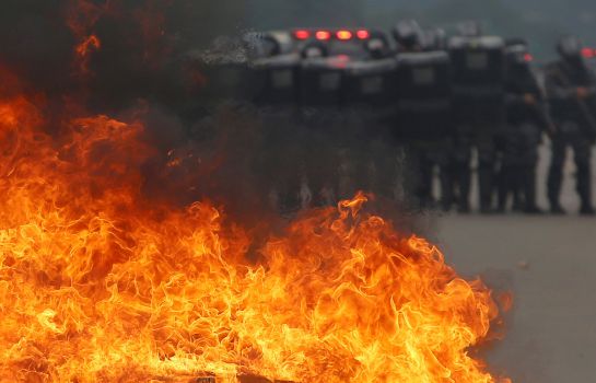 Agentes antidisturbios, junto a una barricada cerca del Congreso, en Brasilia. Agentes antidisturbios, junto a una barricada cerca del Congreso, en Brasilia.
