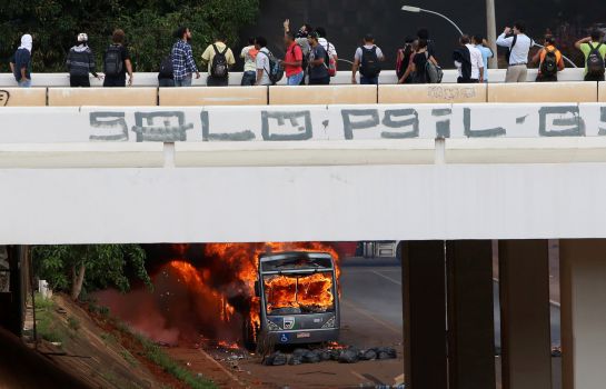 Varias personas observan el vehículo, quemado frente al Congreso, en Brasilia. Varias personas observan el vehículo, quemado frente al Congreso, en Brasilia.