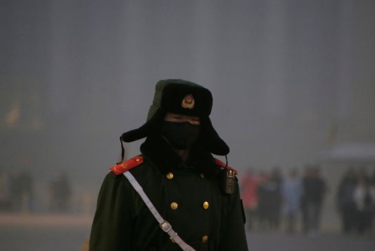 Un policía paramilitar se protege de la contaminación con una máscara en la plaza de Tiananmen. Un policía paramilitar se protege de la contaminación con una máscara en la plaza de Tiananmen.