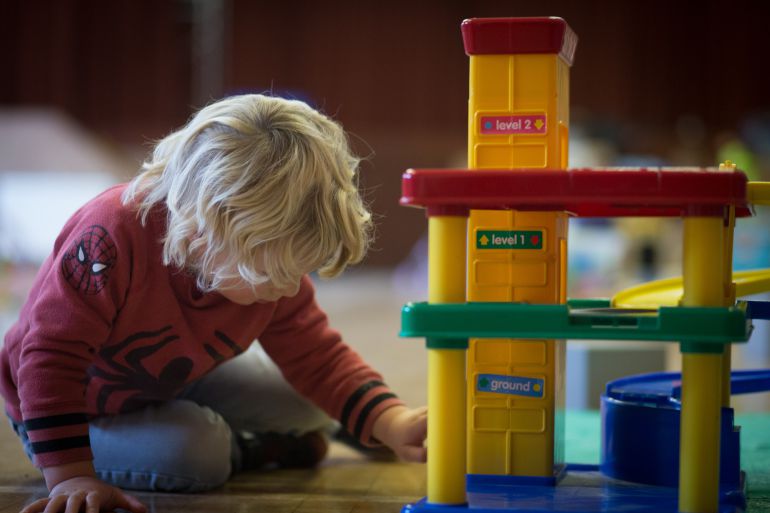 Un niño juege en el suelo a los coches. Un niño juege en el suelo a los coches.