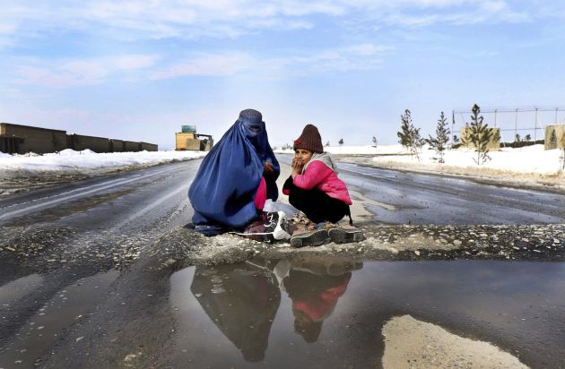 Una mujer y una niña afganas piden limosna en una calle de Kabul, Afganistán Una mujer y una niña afganas piden limosna en una calle de Kabul, Afganistán