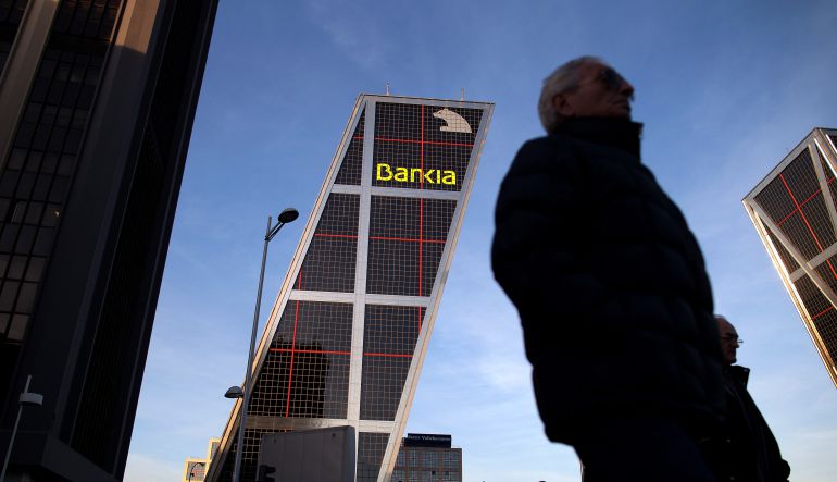 Ciudadanos caminan ante las oficinas centrales de Bankia en Madrid Ciudadanos caminan ante las oficinas centrales de Bankia en Madrid