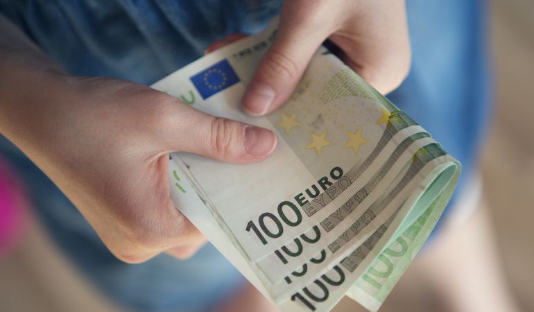 Un niño con billetes de cien euros. Un niño con billetes de cien euros.