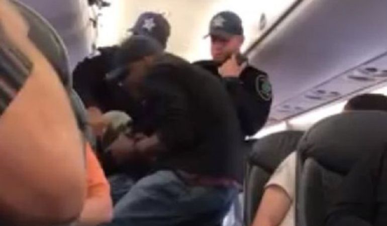 Los guardas de seguridad sacando al pasajero de su asiento. Los guardas de seguridad sacando al pasajero de su asiento.