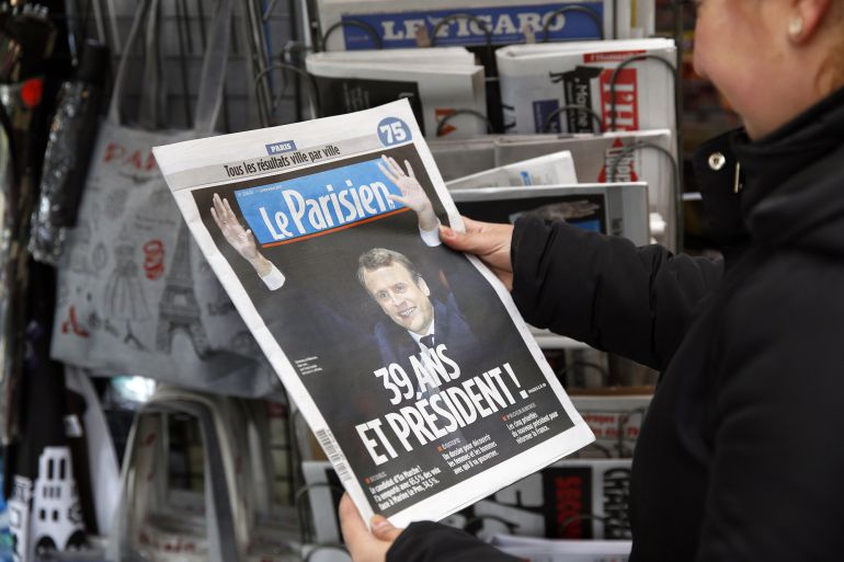 Una mujer mira la portada de 'Le Parisien' con la foto de Macron como ganador de las presidenciales en Francia Una mujer mira la portada de 'Le Parisien' con la foto de Macron como ganador de las presidenciales en Francia