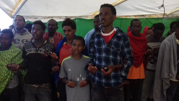 Eritreos rezando en la cubiera del Golfo Azzurro mientras viajan a Sicilia Eritreos rezando en la cubiera del Golfo Azzurro mientras viajan a Sicilia