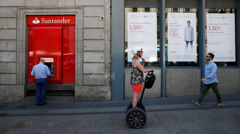 Un cajero del Santander frente a una oficina del Popular Un cajero del Santander frente a una oficina del Popular