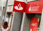 FILE PHOTO: A woman walks past a Banco Popular and Santander banks offices in Barcelona, Spain June 7, 2017. REUTERS/Albert Gea/File Photo