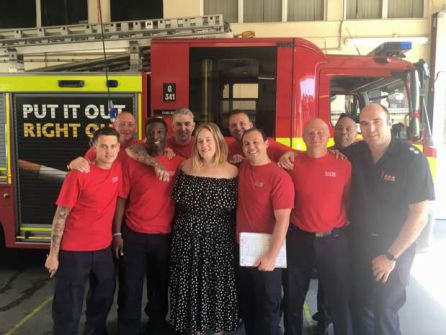 Adele posando con los bomberos en la estación. Adele posando con los bomberos en la estación.