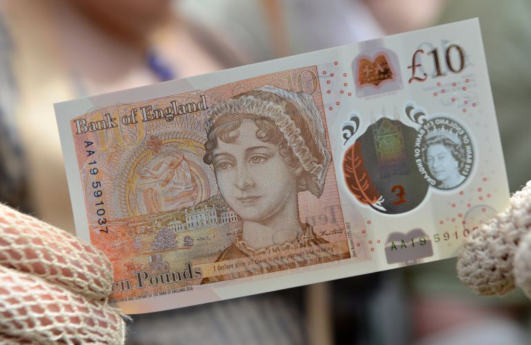 Una mujer ataviada con un traje de la época posa con el nuevo billete de diez libras con el rostro de Jane Austen. Una mujer ataviada con un traje de la época posa con el nuevo billete de diez libras con el rostro de Jane Austen.