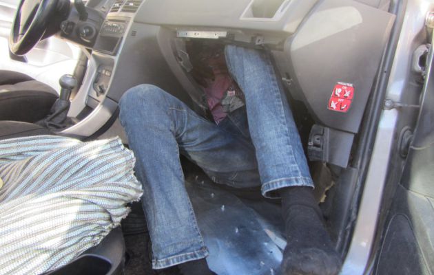 Persona hacinada en el salpicadero de un coche Persona hacinada en el salpicadero de un coche